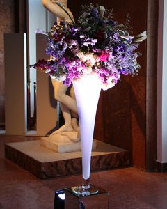 Rendezvénydíszítés nagy fehér vázában lila virágok
